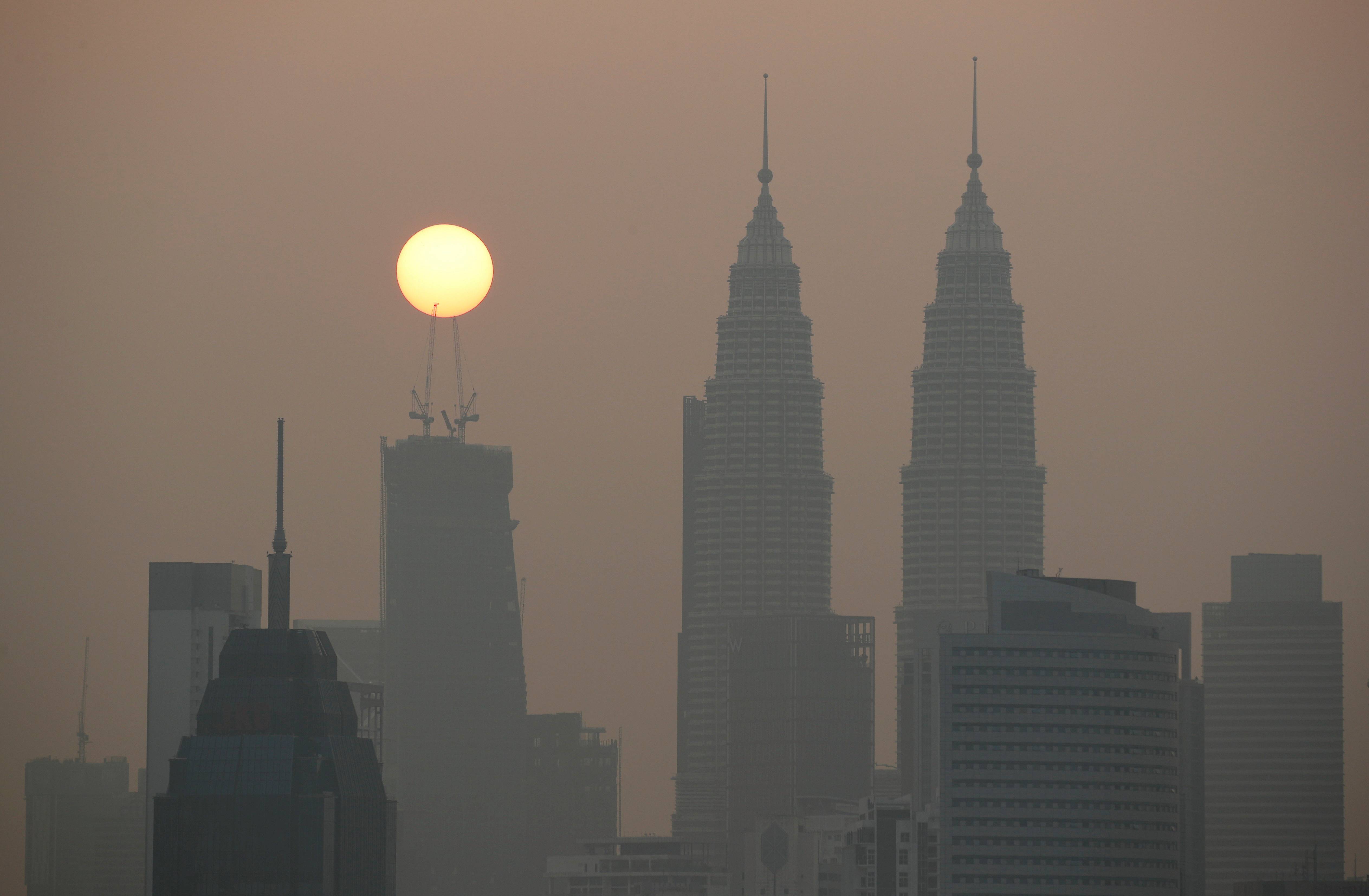 Sun rises above Kuala Lumpur's skyline on a hazy day in Kuala Lumpur