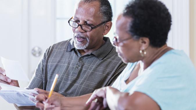 elderly senior couple discuss finances_iStock-1301117815 Senior couple at home paying bills stock photo