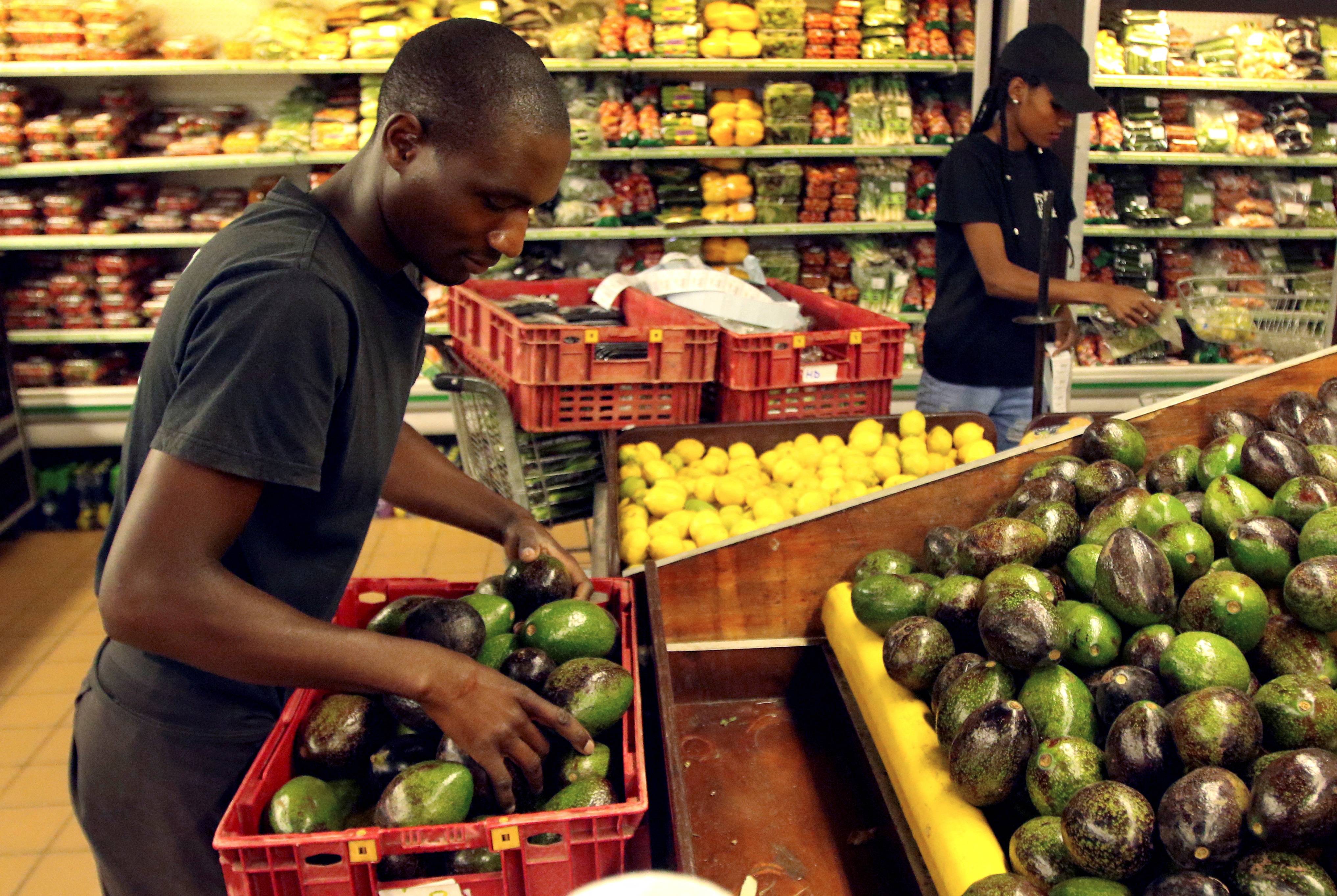 Workers pack out avocados at a fruit and vegetable market store in Harare